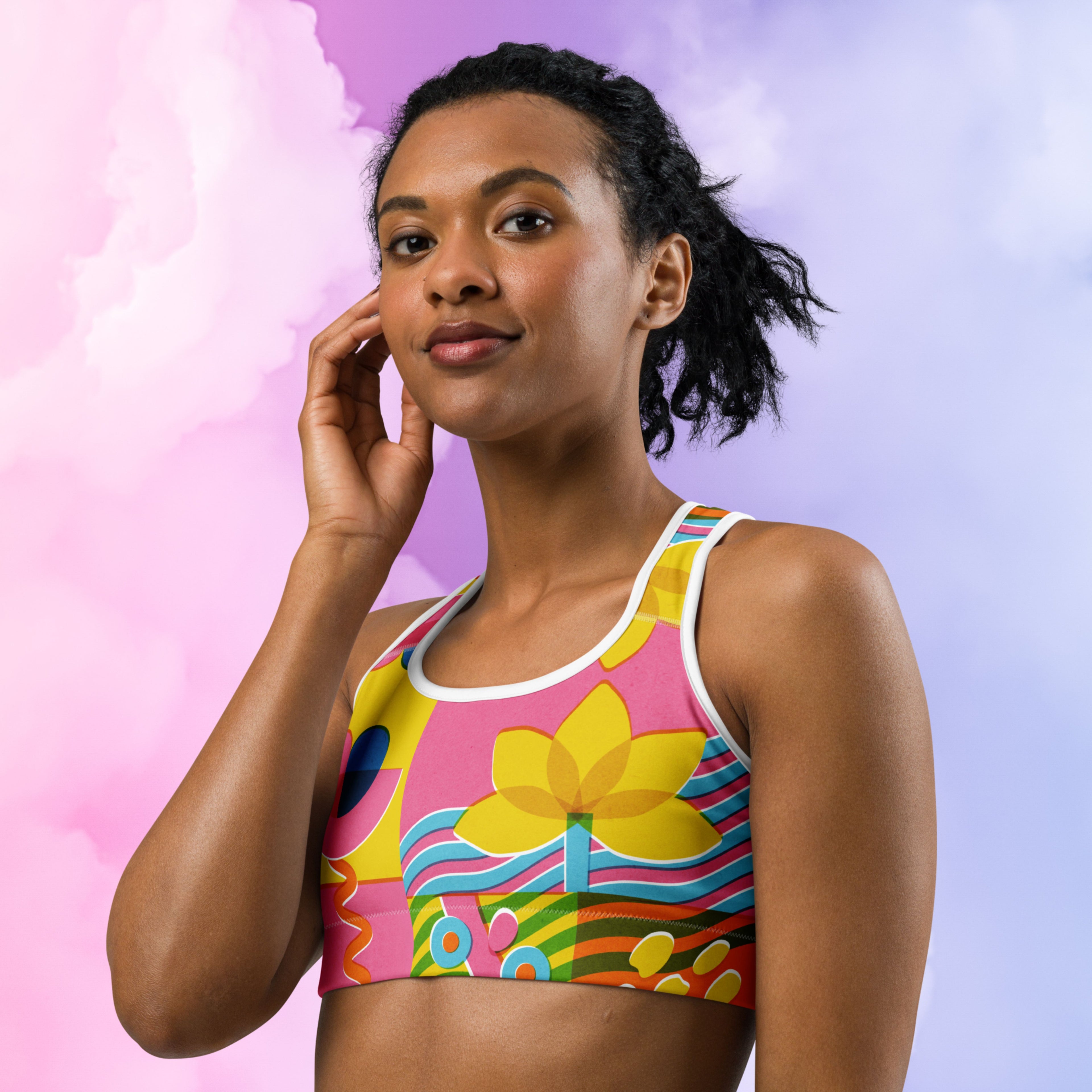 Woman wearing a colorful sports bra against a pink and purple gradient background
